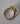 Side profile of oval diamond three-stone ring in 18k yellow gold showing setting depth and band profile