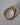 Side profile of oval diamond three-stone ring in 18k yellow gold showing setting depth and band profile