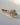 Three-stone oval diamond ring with kite sides in yellow gold, wider front view on surface