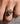 A close-up of a hand wearing a silver ring with a large oval-cut yellow diamond in a prong setting, resting on a textured gray surface.