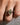 A close-up of a hand wearing a silver ring with a large oval-cut yellow diamond in a prong setting, resting on a textured gray surface.